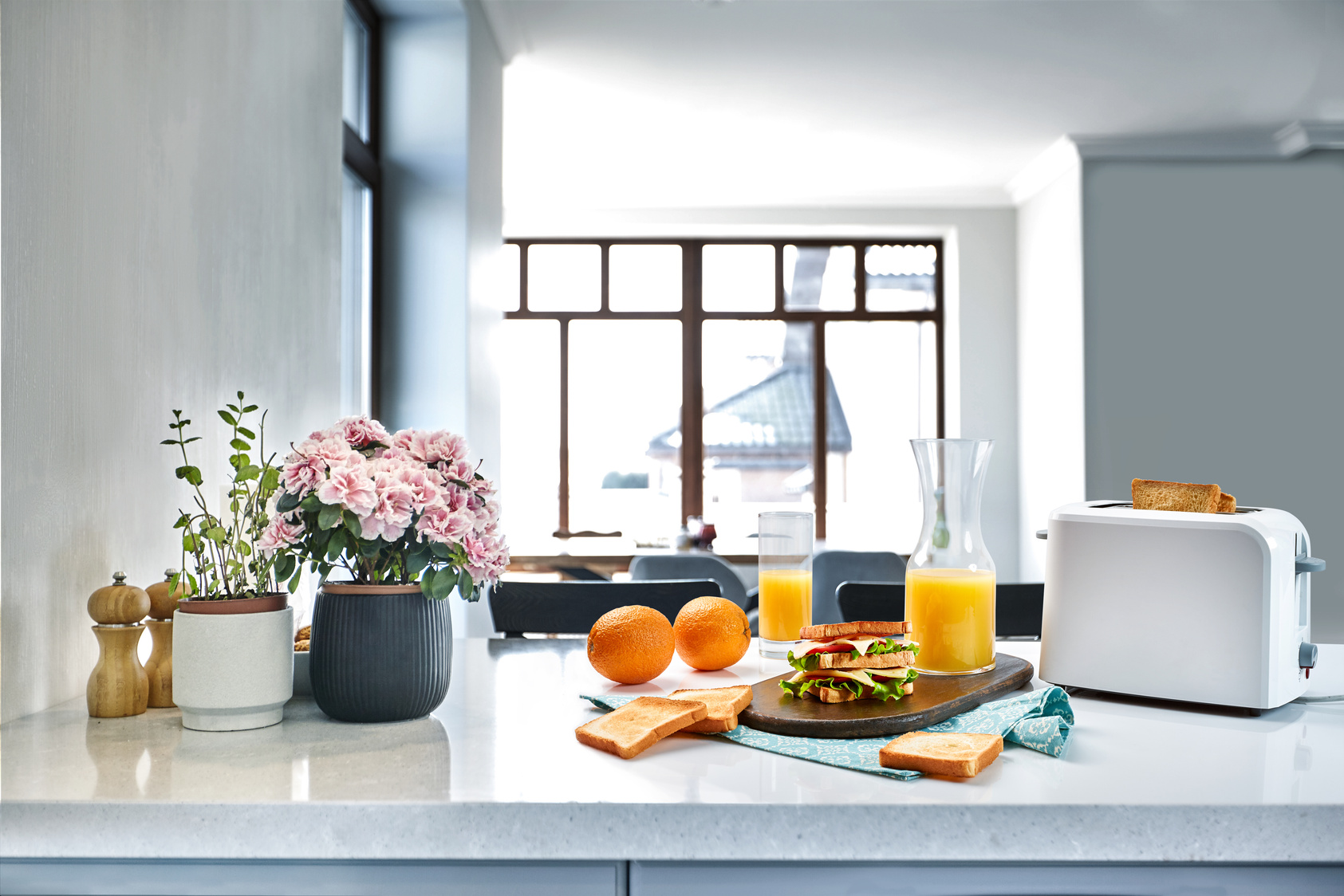 White Electric Bread Toaster with Orange Juice with Sandwich on Kitchen Table. Breakfast in the Cozy Kitchen.